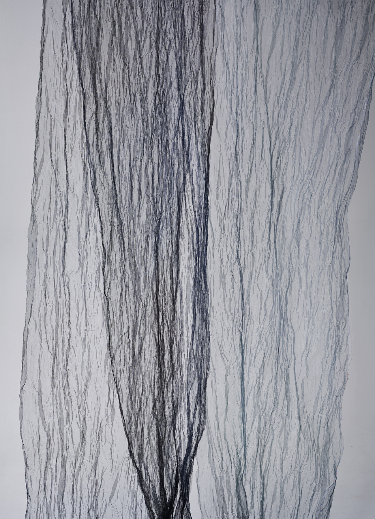 Light sheer metal fabric with vertical plissé and allover color blur print